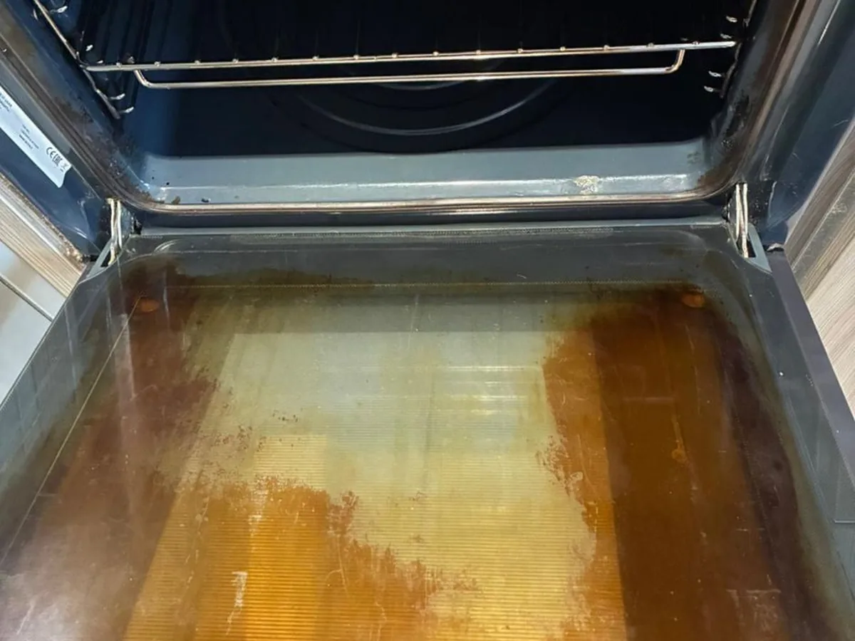 Stained oven door glass before cleaning